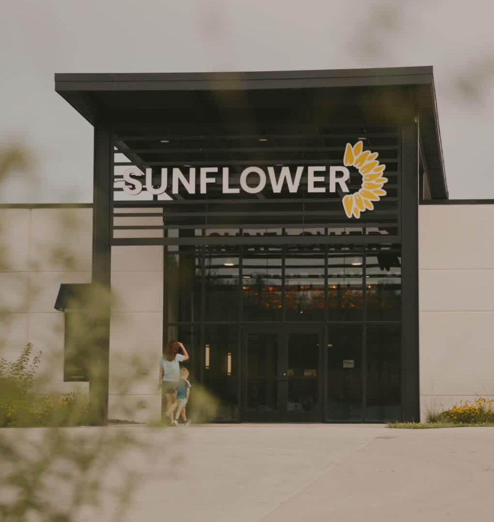 Front view of the Sunflower Child Development Center in Decorah, featuring a sign reading "SUNFLOWER" and a sunflower graphic above the entrance.